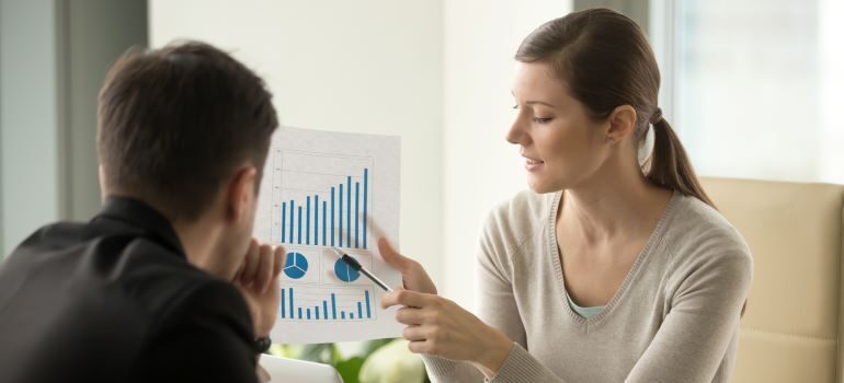 Woman showing growth charts to another person.