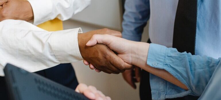 A close-up of two people shaking hands in an office.