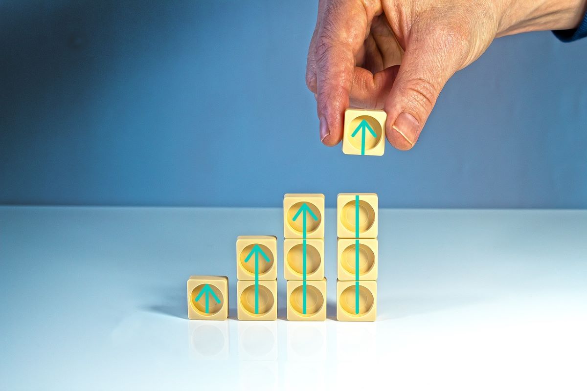 Person stacking up small wooden dice as a visual representation of how to boost sales efforts with CRM