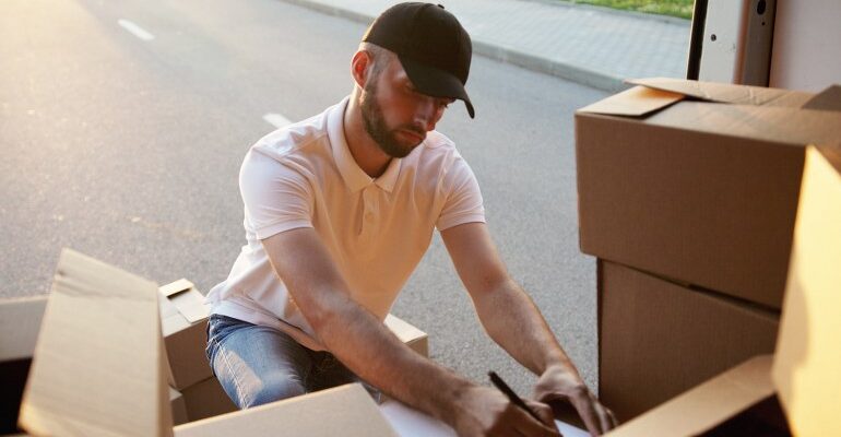 A person packing boxes into a van.