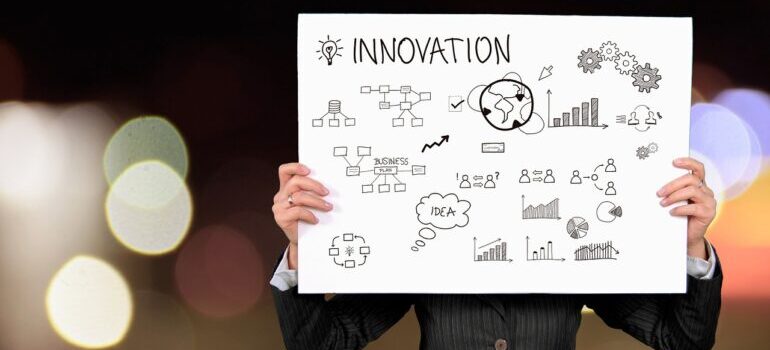 A person holding a board with drawings about innovation.