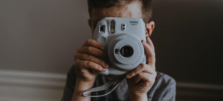 A child holding a polaroid camera.