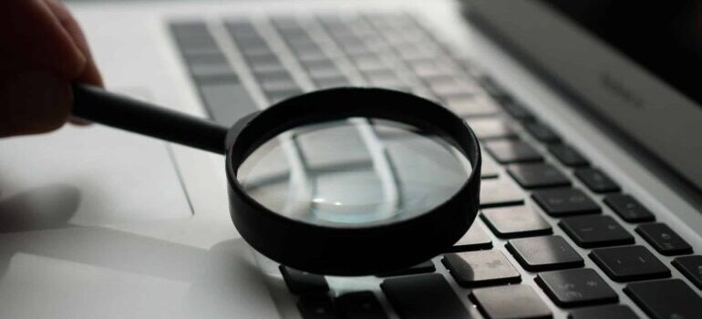 A magnifying glass over a laptop keyboard.
