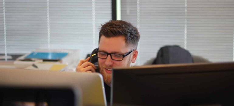 A man talkig on the phone, providing customer support.