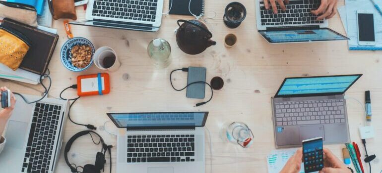 A group of people cross-comparing CRM systems and electronic gadgets.