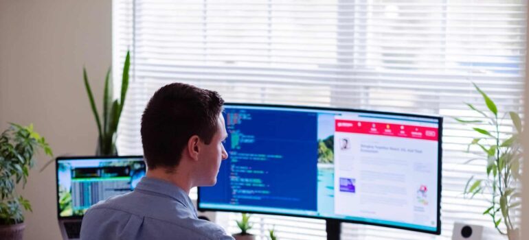 A man sitting in front of a PC screen.