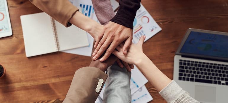 Hands of people giving support to each other in an office