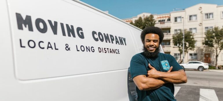 A person in front of a moving company van.