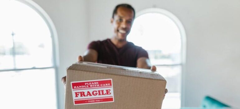 A man carrying a box labeled "fragile".
