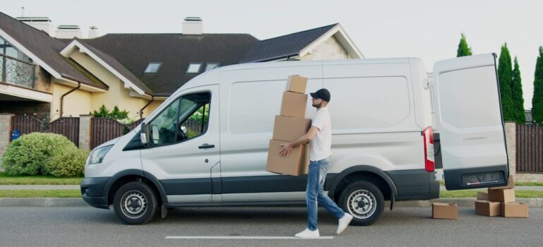 A mover carrying moving boxes, symbolizing how personalized offers can help your moving company stand out.