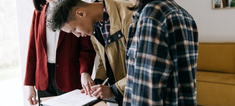 Customers signing a contract with the moving business.