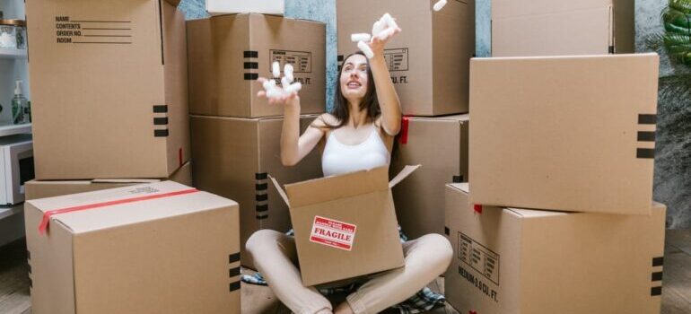 A person sitting between moving boxes.