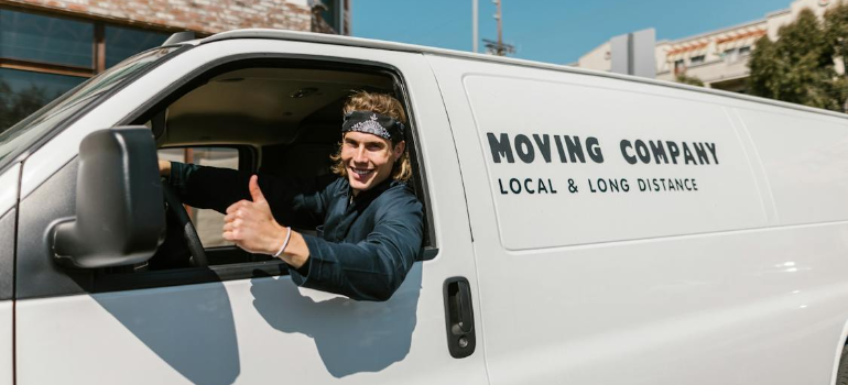 A man showing thumbs up in a moving van