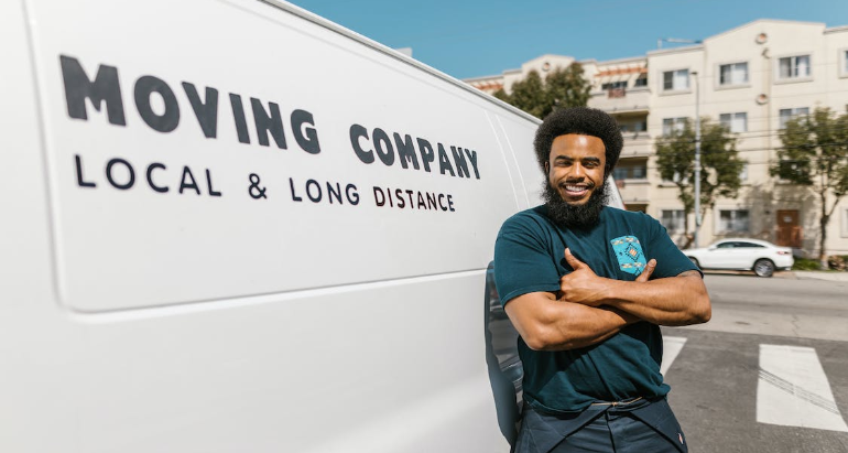 A man standing next to a moving company van