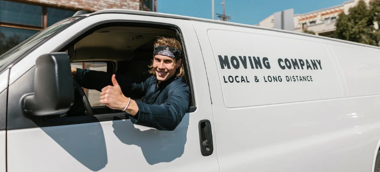A moving company worker driving a van