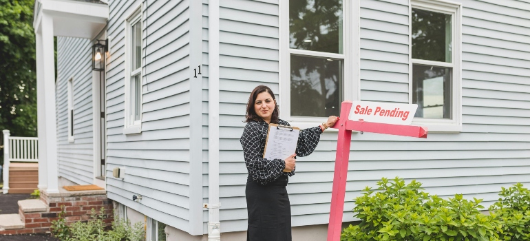 A real estate agent in front of a home for sale